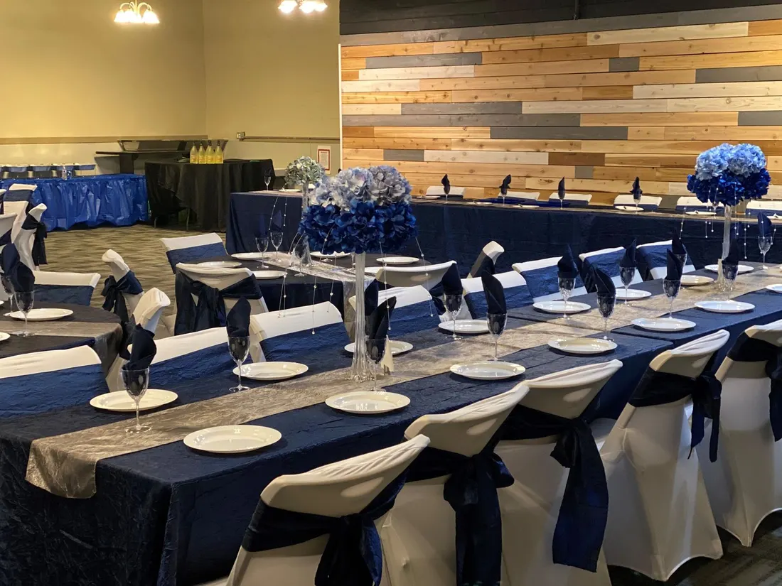 A Main Event event space formally set with navy linens and floral centerpieces